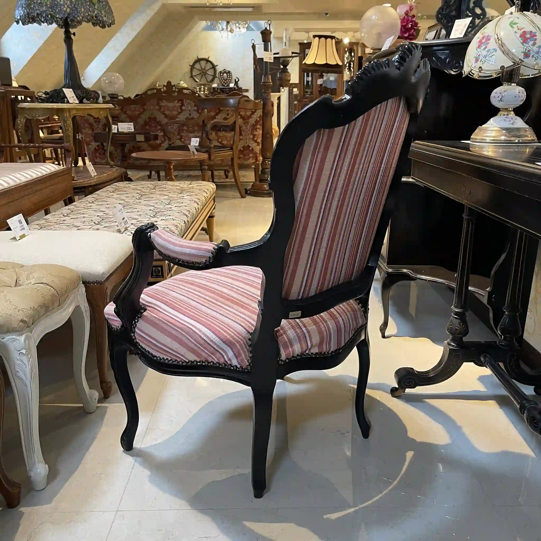 Vintage armchair with carved decoration, cabriole legs, and black lacquer