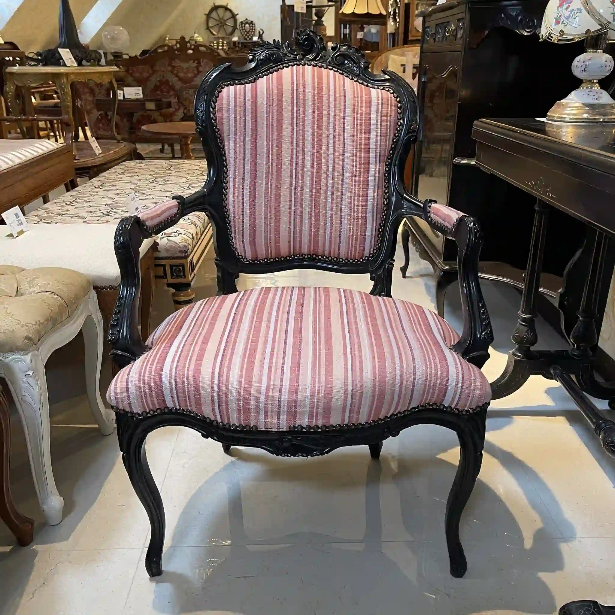 Vintage armchair with carved decoration, cabriole legs, and black lacquer